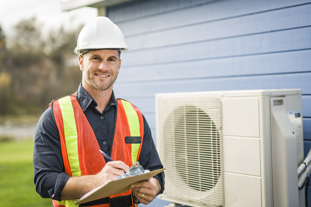 A worker inspecting a heat pump